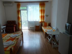 ツァレヴォにあるSunhouse Roomsのベッド2台とテレビが備わる小さな客室です。