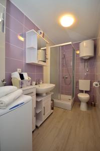 uma casa de banho com um lavatório, um WC e um chuveiro em Apartment Sunset em Primošten