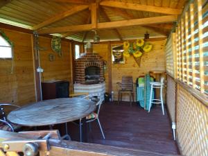Lesny domek في مينززدرويه: شرفة كابينة مع طاولة ومدفأة