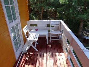 eine Veranda mit einem Tisch und Stühlen auf einer Terrasse in der Unterkunft Lesny domek in Misdroy