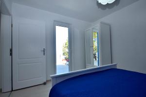 - une chambre avec un lit bleu et un miroir dans l'établissement Apartment Sunset, à Primošten