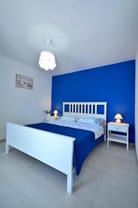 um quarto azul com uma cama e uma parede azul em Apartment Sunset em Primošten