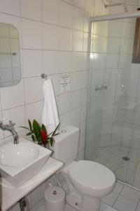 
a white toilet sitting in a bathroom next to a sink at Pousada Praia de Itamambuca in Ubatuba
