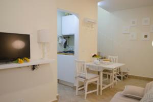 Una cocina y una sala de estar con una mesa y un televisor. en La Nicchia - Serena Tuscany Homes, en Cortona