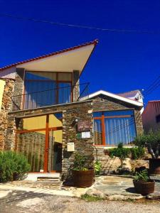 una casa de piedra con ventanas y plantas delante de ella en Casa d'Avó Faia, en Morais