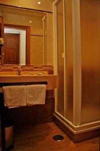 y baño con lavabo, espejo y toallas. en Hostal Victoria I, en Madrid