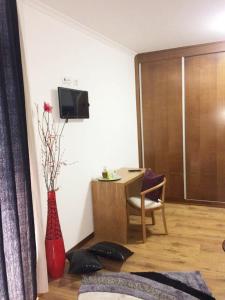 a living room with a table and a red vase with flowers at Casa d'Avó Faia in Morais +21 photos