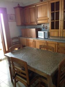 cocina con mesa y algunos armarios de madera en Abitazione, en Galatone