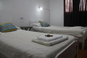 two beds with towels on them in a room at Hotel Vuelta del Ombu in Gobernador Ingeniero Valentín Virasoro