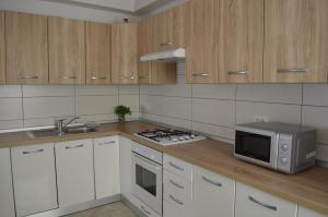a kitchen with white cabinets and a microwave on a counter at Apartment Michael in Krk