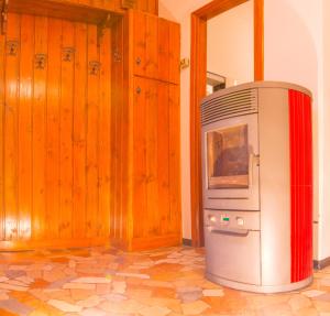 a small refrigerator in a room with wooden walls at Balcon des Alpes in Teglio