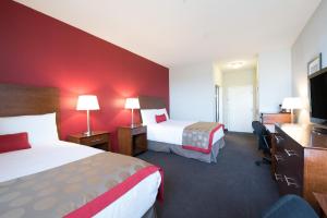 um quarto de hotel com duas camas e uma televisão de ecrã plano em Bakken Airport XWA Hotel & Studios em Williston