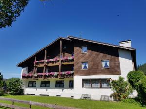 un edificio con un balcón con flores. en Alpenlandhaus, en Pfronten