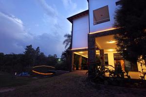 a house with a lit up facade at night at Los Lagos Resort Hotel in Capiatá