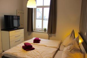 ボルクムにあるAltstadt Wohnung 1 "Lütje Hörn"のベッドルーム1室(赤いタオルが付いたベッド1台付)