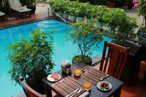 una mesa y sillas frente a una piscina en Phuc Thao Villa en Hoi An