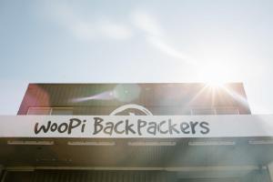 a sign on the front of a woodott back packers building at Woopi Backpackers in Woolgoolga