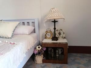 a bedroom with a bed and a table with a clock at Chanathinat Place in Udon Thani