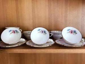 three tea cups and saucers on a wooden shelf at Chanathinat Place in Udon Thani