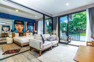 a bedroom with a bed and a large window at The Deck Condominium by Lofty in Patong Beach