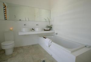 a white bathroom with a tub and a toilet at Tonic Hotel in Lovedale