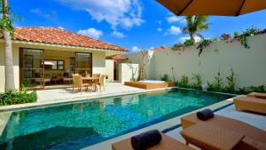 a villa with a swimming pool and a house at The Uza Terrace Beach Club Villas in Yomitan