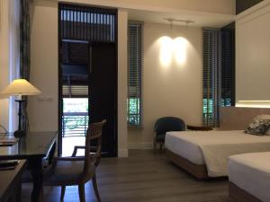 a hotel room with a bed and a desk and a desk at iuDia Hotel in Phra Nakhon Si Ayutthaya