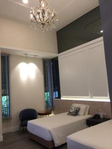 a bedroom with two beds and a chandelier at iuDia Hotel in Phra Nakhon Si Ayutthaya