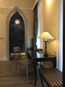 a room with a desk with a lamp and a chair at iuDia Hotel in Phra Nakhon Si Ayutthaya