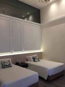 a bedroom with two beds and a chandelier at iuDia Hotel in Phra Nakhon Si Ayutthaya