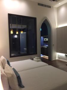 a bedroom with a bed and a large window at iuDia Hotel in Phra Nakhon Si Ayutthaya