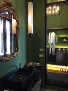 a bathroom with a black sink and a mirror at iuDia Hotel in Phra Nakhon Si Ayutthaya