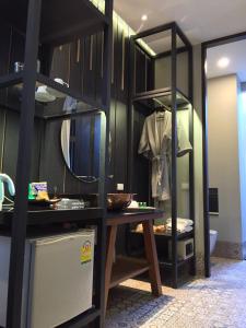 a room with a table and a shelf with a mirror at iuDia Hotel in Phra Nakhon Si Ayutthaya