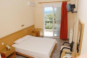 a bedroom with a bed and a window with a view at Hotel Aphroditi in Agia Paraskevi