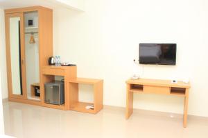 a room with a tv and a table with a mirror at Naka Hotel Kupang in Kupang