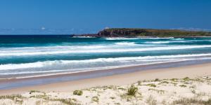 una playa de arena con vistas al océano en Windang Tourist Park en Windang