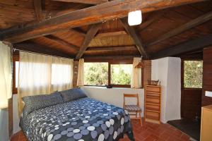 a bedroom with a bed in a room with wooden ceilings at Villa Paradisino in Orbetello