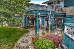 a home with a blue house with a patio at Sunny Shuswap B&B in Chase