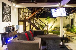 a living room with a couch and a tv at Villa Gardenia in Seminyak