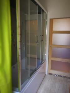 a glass shower in a room with a door at Résidence le 09 in Uzerche