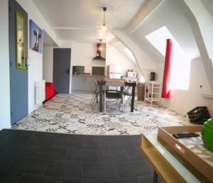 a living room with a table and a kitchen at Résidence le 09 in Uzerche