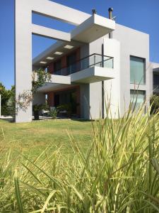 a white house with tall grass in the foreground at Villa Evi in Ixia