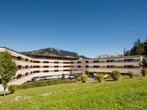 una vista esterna di un edificio con montagne sullo sfondo di TUI BLUE Fieberbrunn a Fieberbrunn