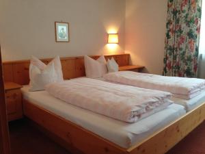 ザンクト・アントン・アム・アールベルクにあるHaus Helmut Schranzのベッドルーム1室(白いシーツと枕のベッド2台付)