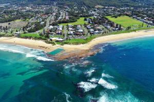 an aerial view of a beach and the ocean at Bulli Beach Tourist Park in Bulli