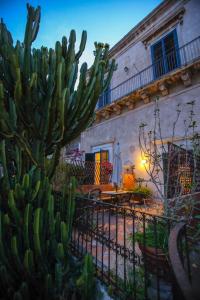 a cactus in front of a house with a fence at L'Orangerie in Modica