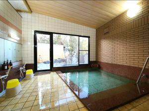 a bathroom with a swimming pool in a room at Kamei no Yu in Yamanouchi