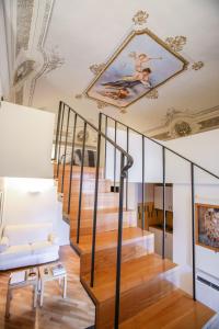 un soggiorno con una scala e un dipinto sul soffitto di L'Orangerie a Modica