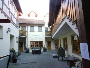een binnenplaats van een gebouw met banken en tafels bij Gästehaus am Westtor in Prichsenstadt