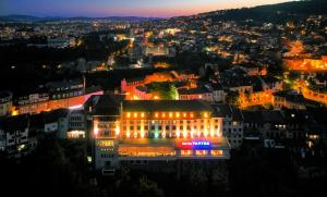 a building lit up at night in a city at Yantra Grand Hotel in Veliko Tŭrnovo